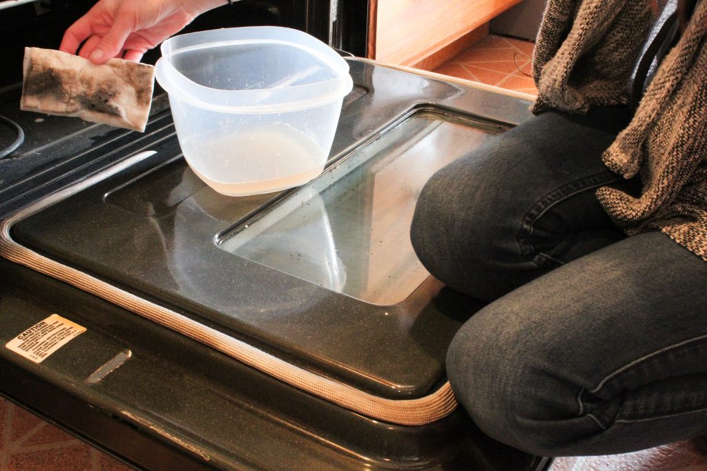 Showing a magic eraser with a bunch of dark stuff on it that I scrubbed off my oven door glass