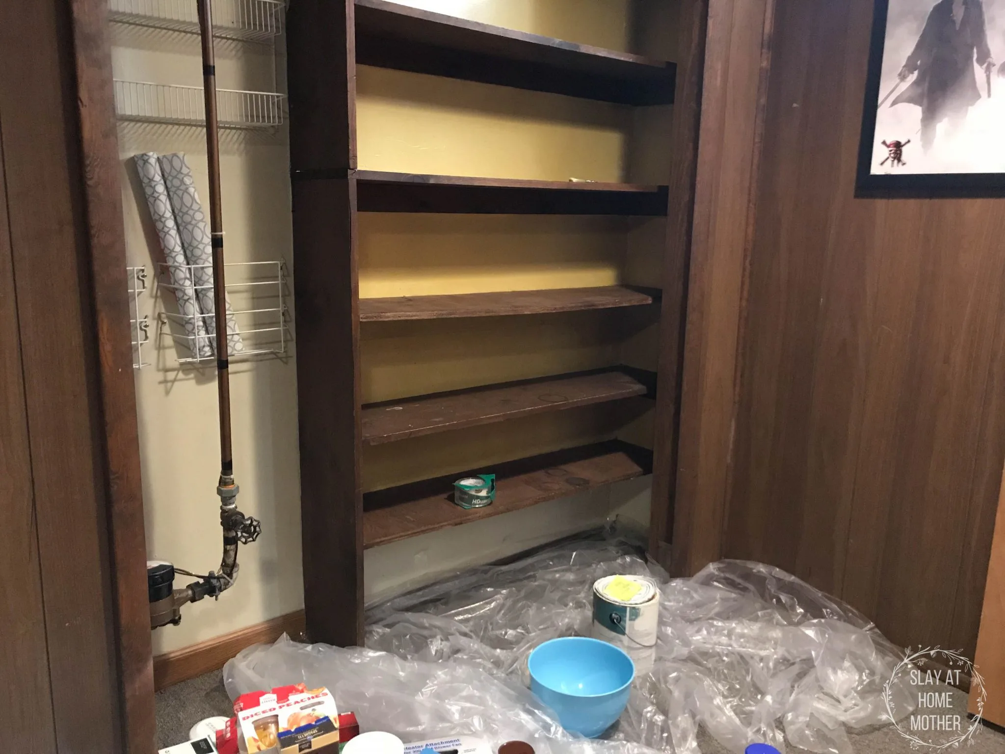 Cleared shelves in my pantry, plastic covering the carpeted basement floor