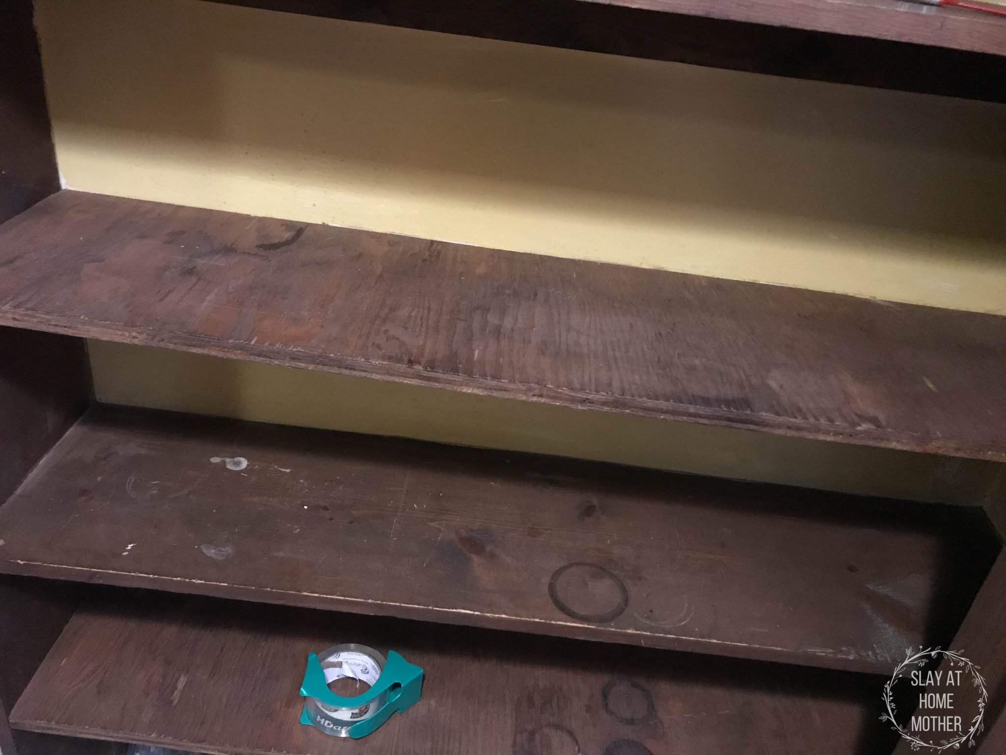 Closeup of our dark brown pantry shelves before painting