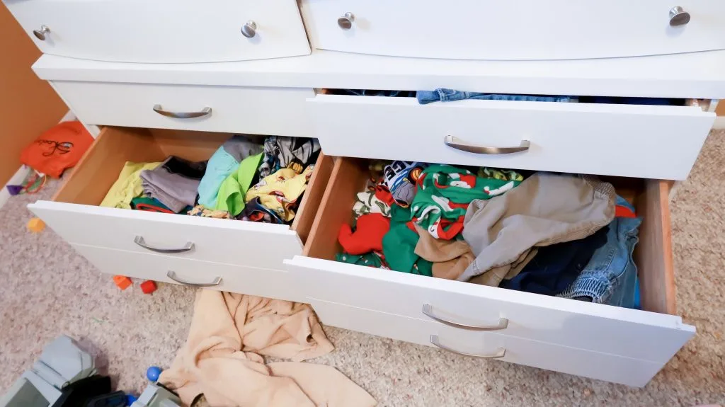 messy clothing drawers in kids room before organizing and folding