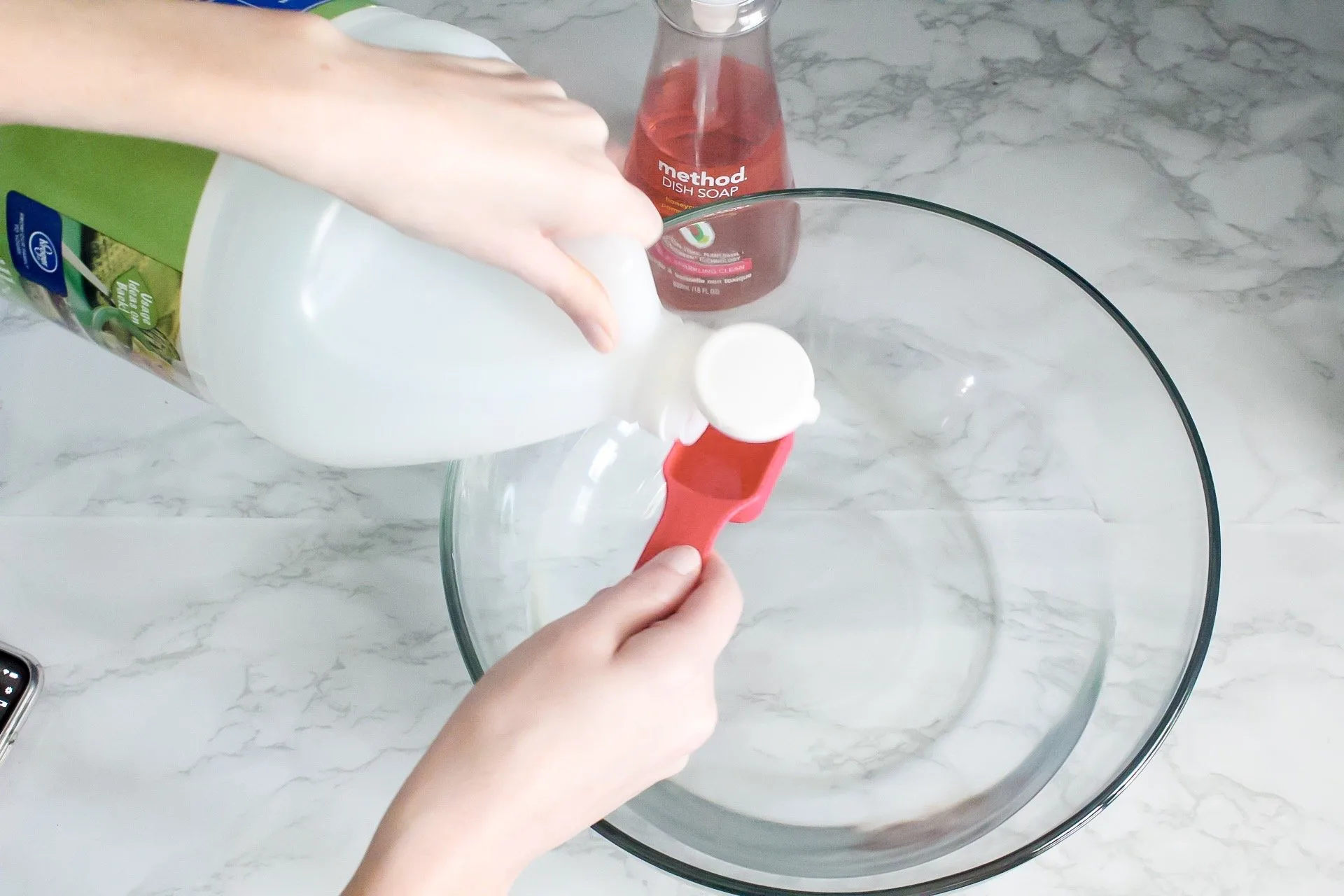 Measuring vinegar into tablespoon to put into homemade cleaning solution