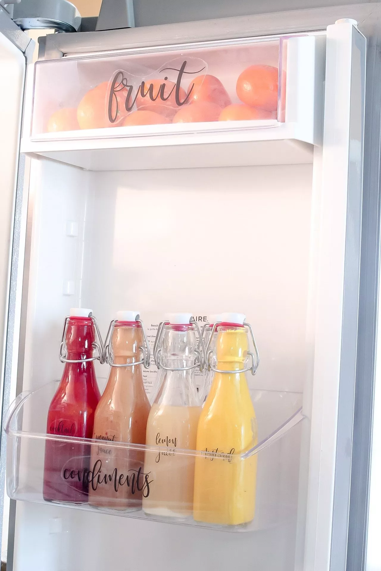 A closeup of our labelled condiment bottles in the right side fridge door