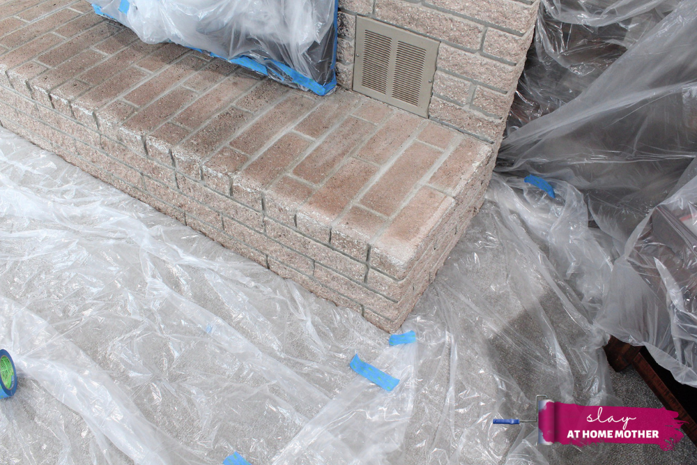 Plastic covering placed in crease between living room floor carpet and fireplace brick