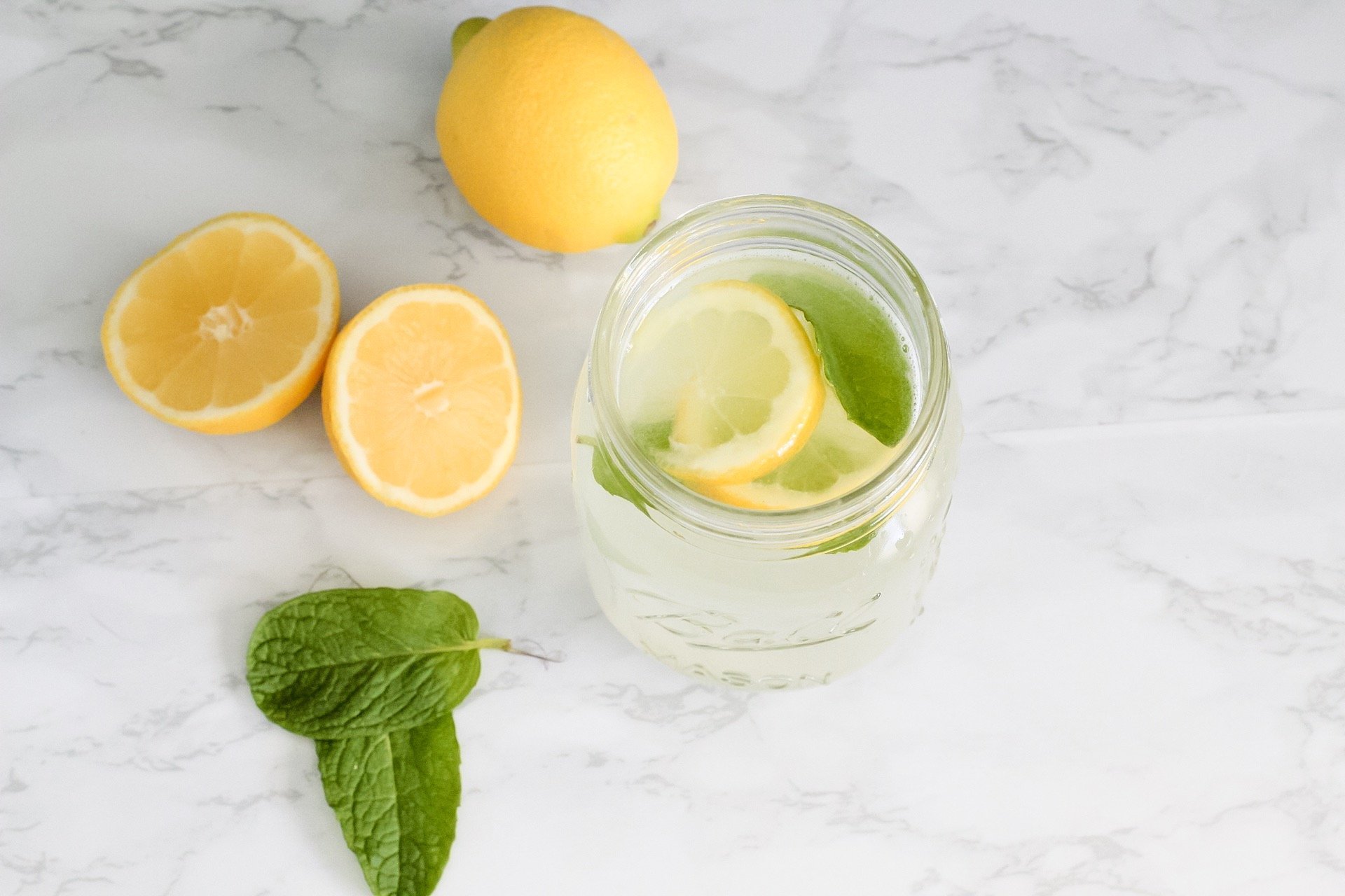 refreshing mint lemonade in a mason jar with fresh lemon slices and sprigs of mint