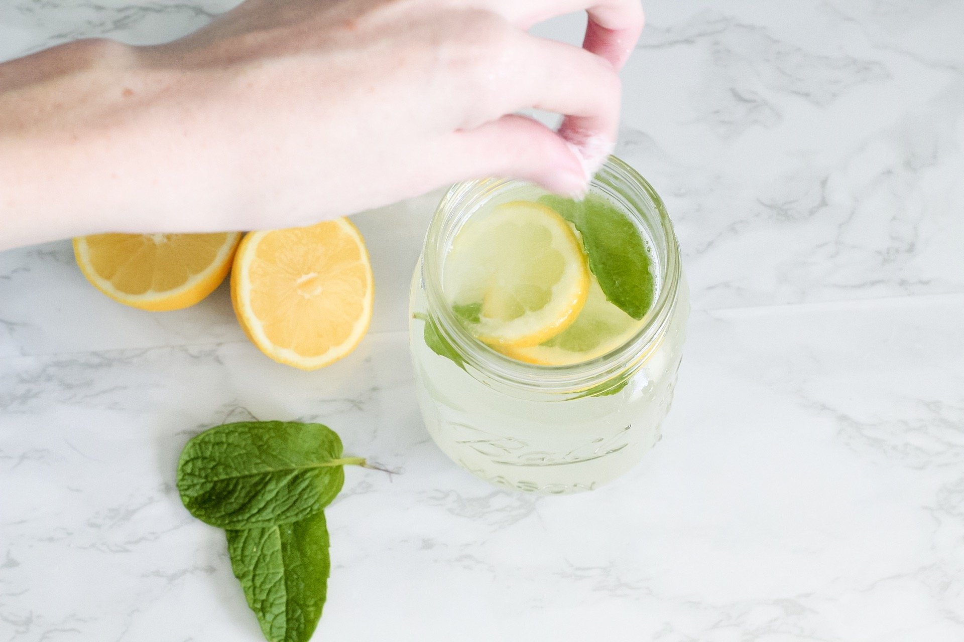 sprinkling sugar in mint lemonade