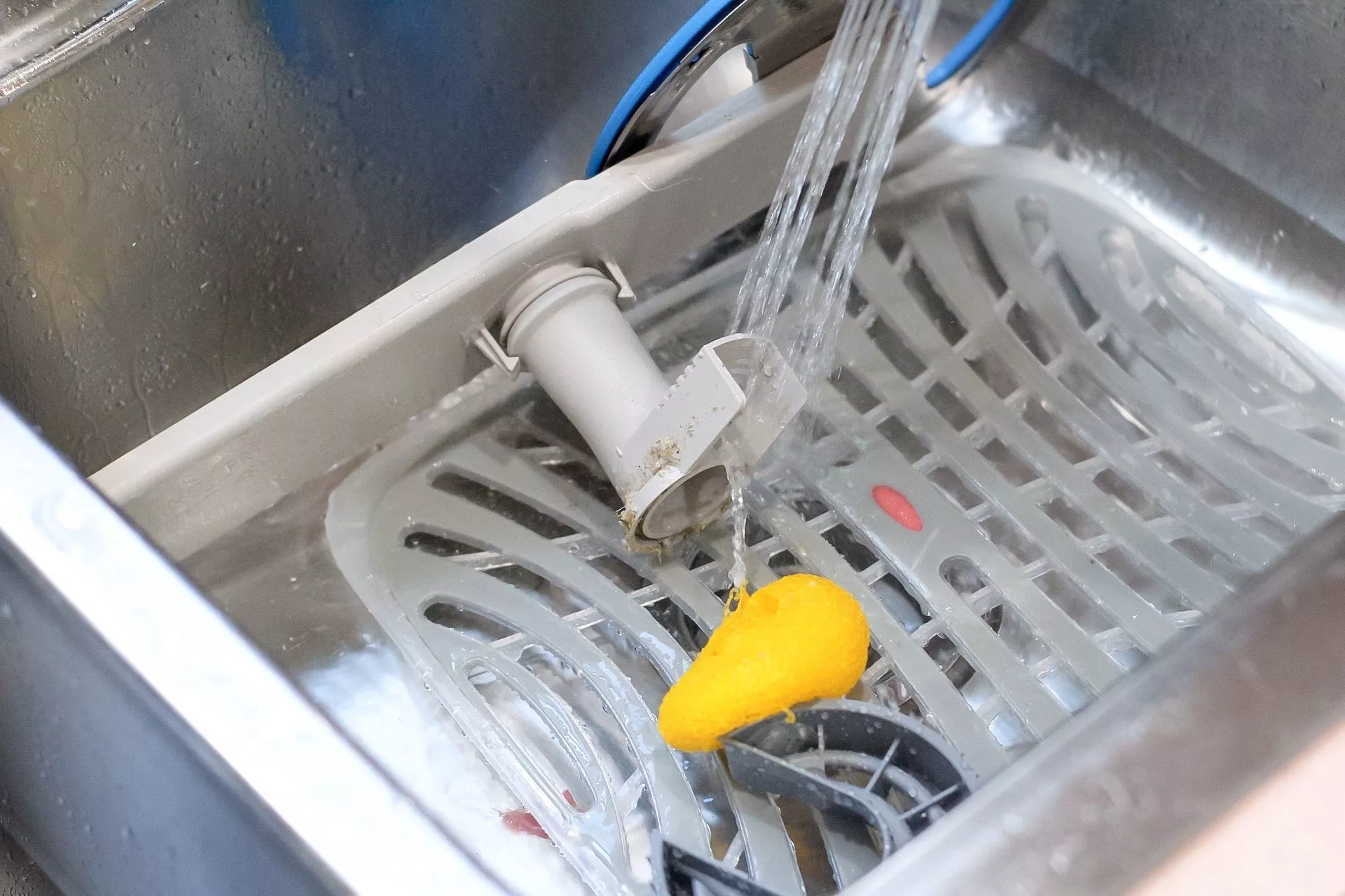 rinsing spinning arm from dishwasher in sink