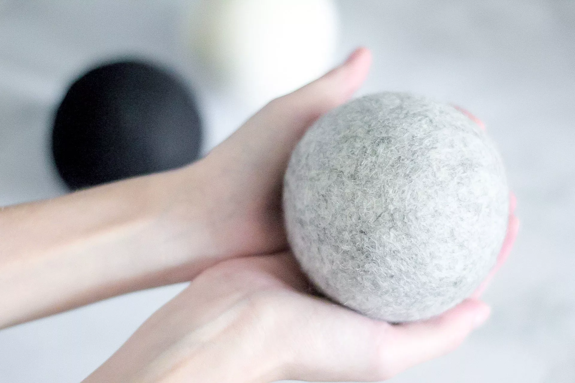 holding dropps wool dryer ball in gray