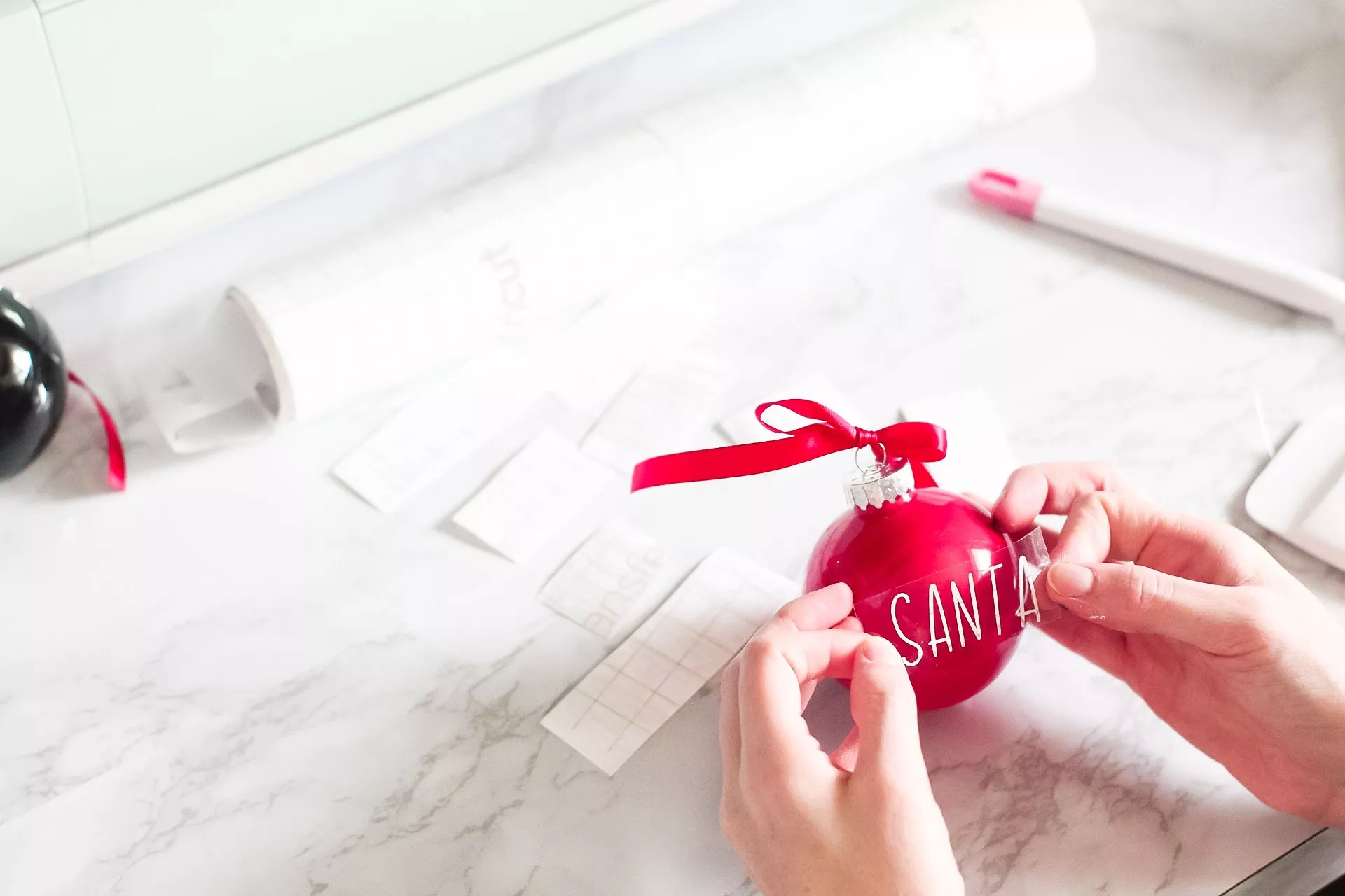 placing vinyl lettering onto christmas ornaments