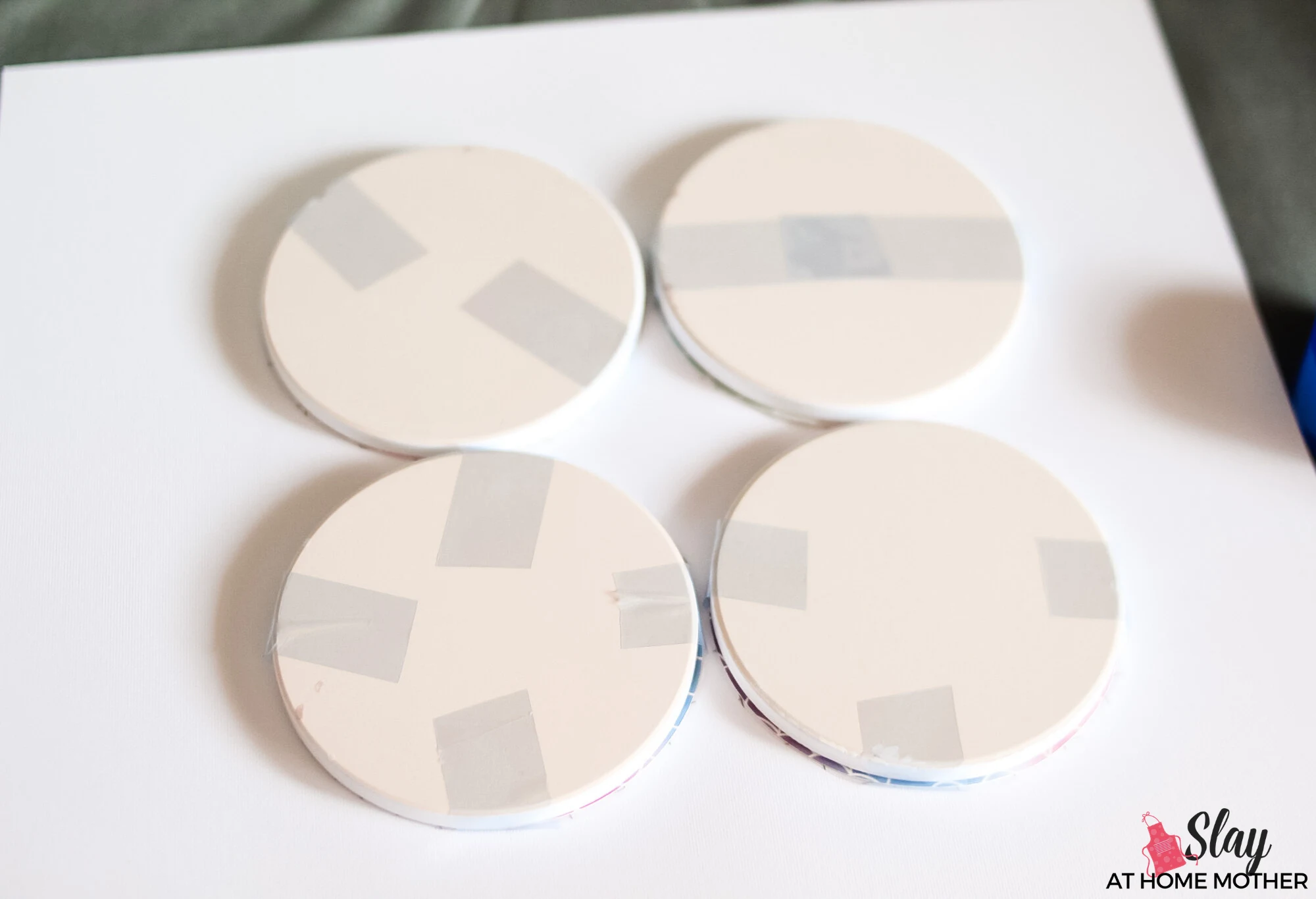 cricut coasters with infusible ink taped on face down on cardstock