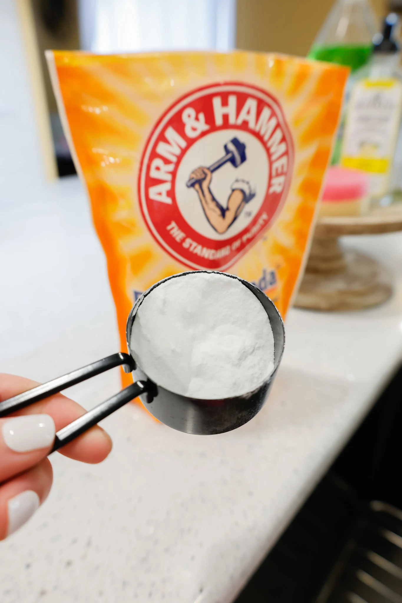 baking soda in a measuring cup in front of a baking soda bag