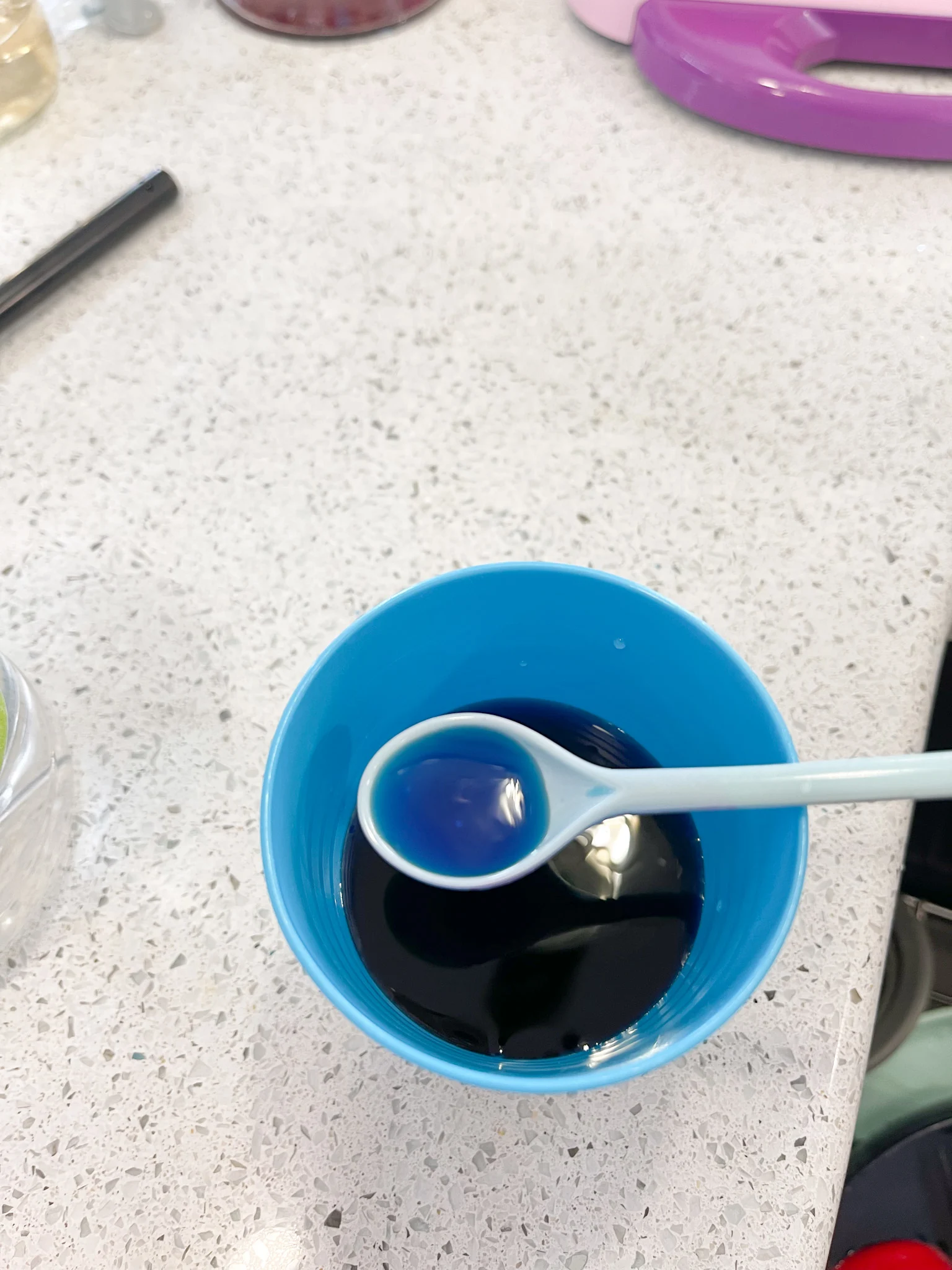 mixing spoon scooping up blue food coloring dye