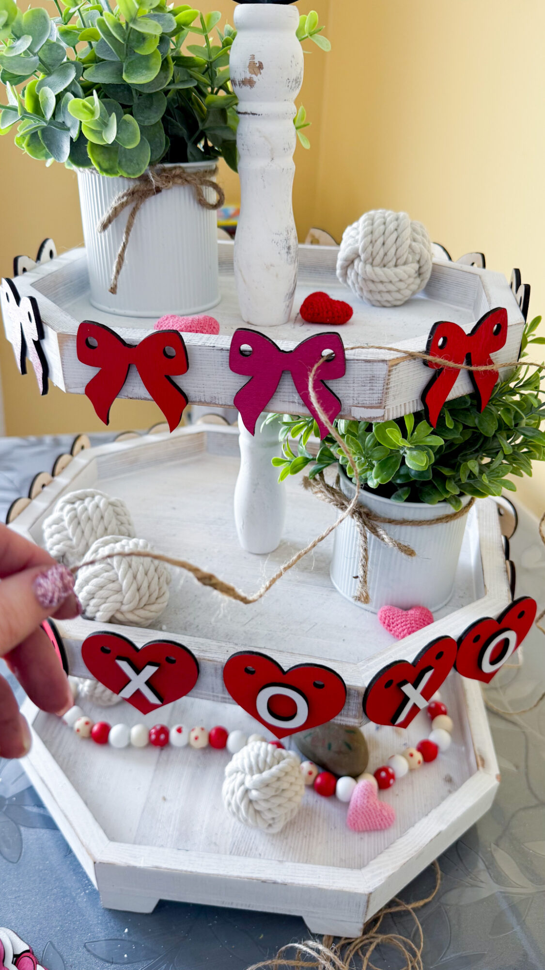 weaving twine through cut holes in faux garland