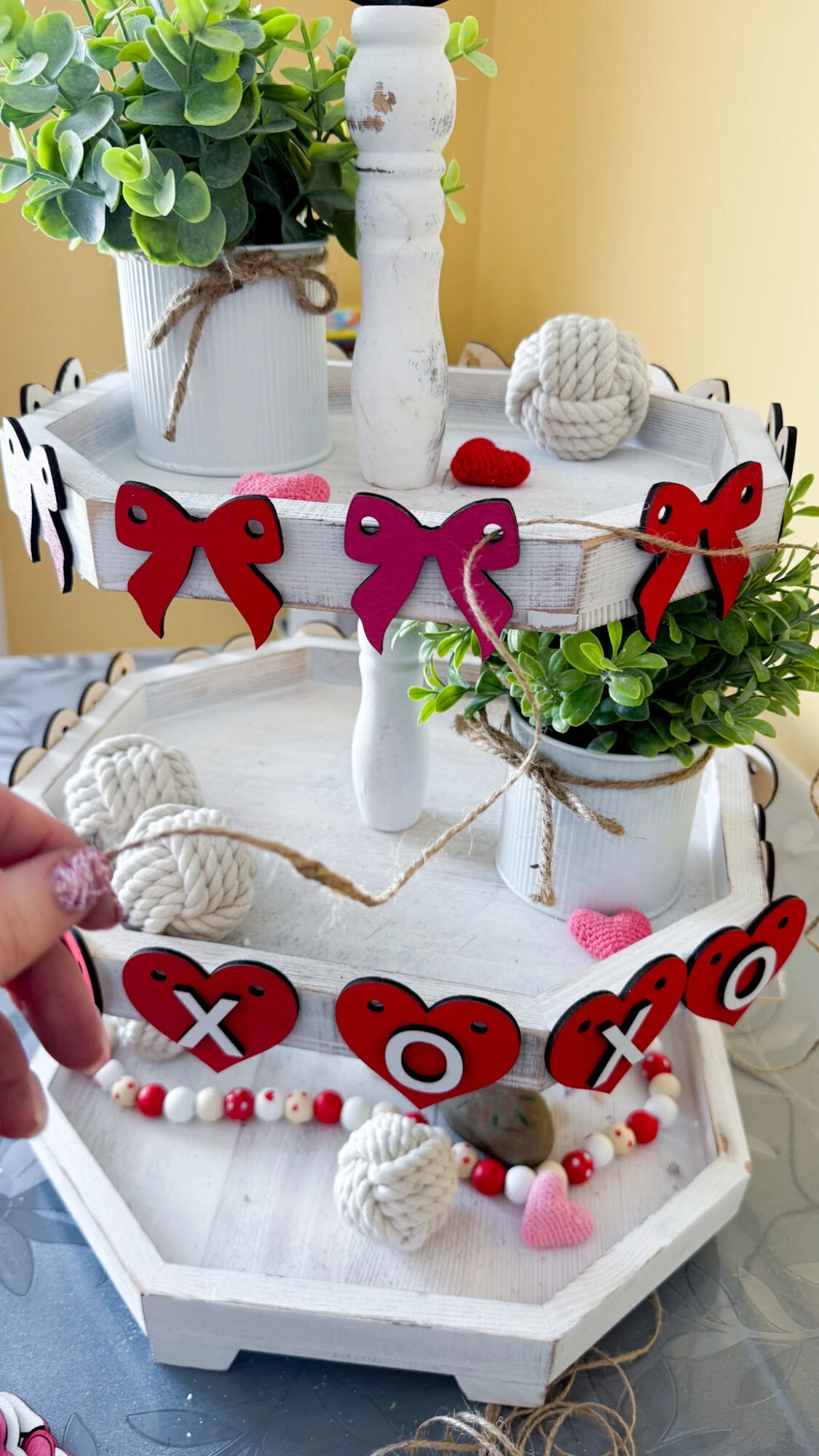 weaving twine through cut holes in faux garland